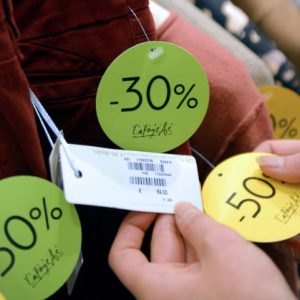 A customer checks a price tag on clothes during the winter sales at the Galeries Lafayette department store in Paris, on January 9, 2013, during the official start of winter sales. AFP PHOTO MIGUEL MEDINA        (Photo credit should read MIGUEL MEDINA/AFP via Getty Images)